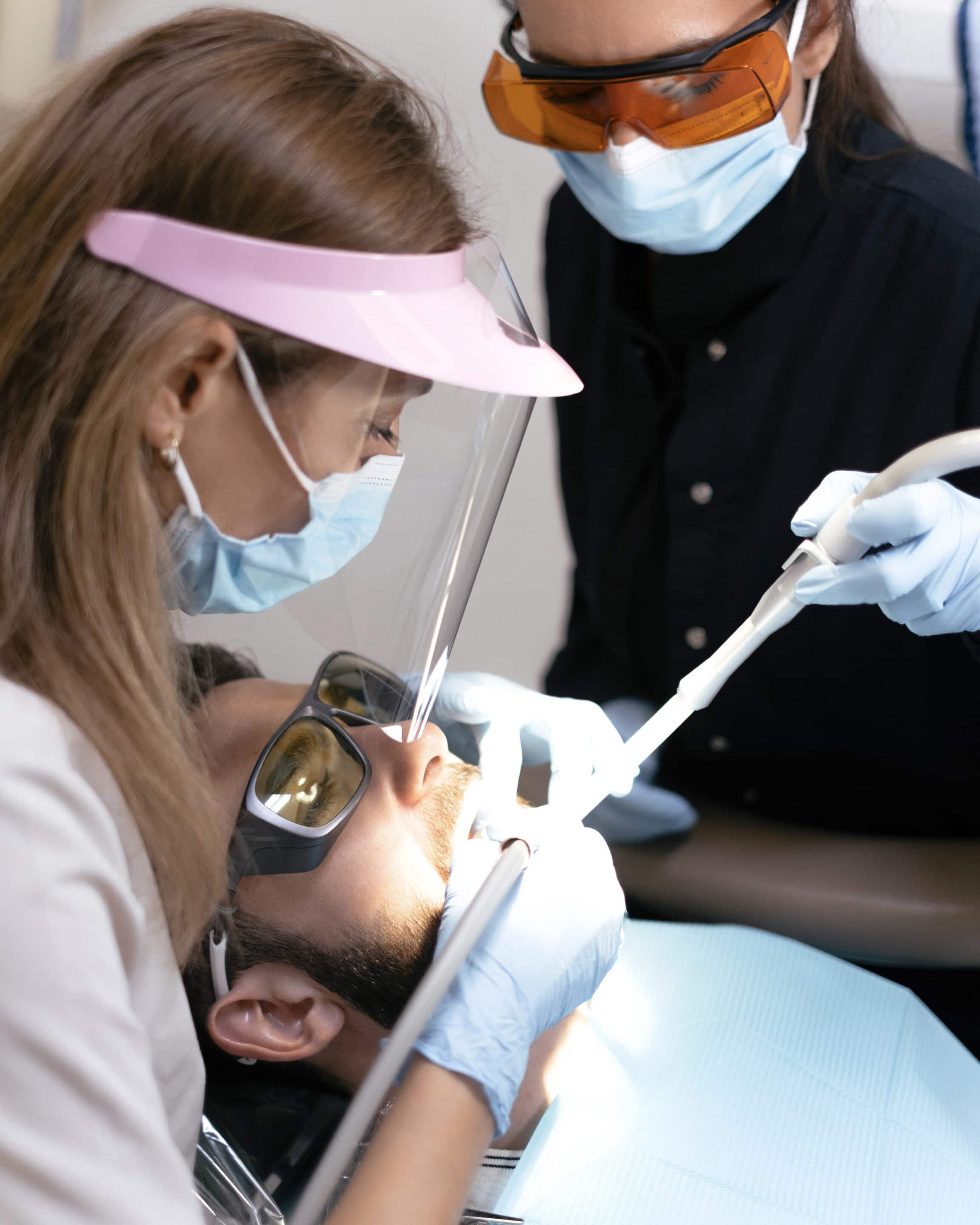 A dentist and assistant treating a patient.